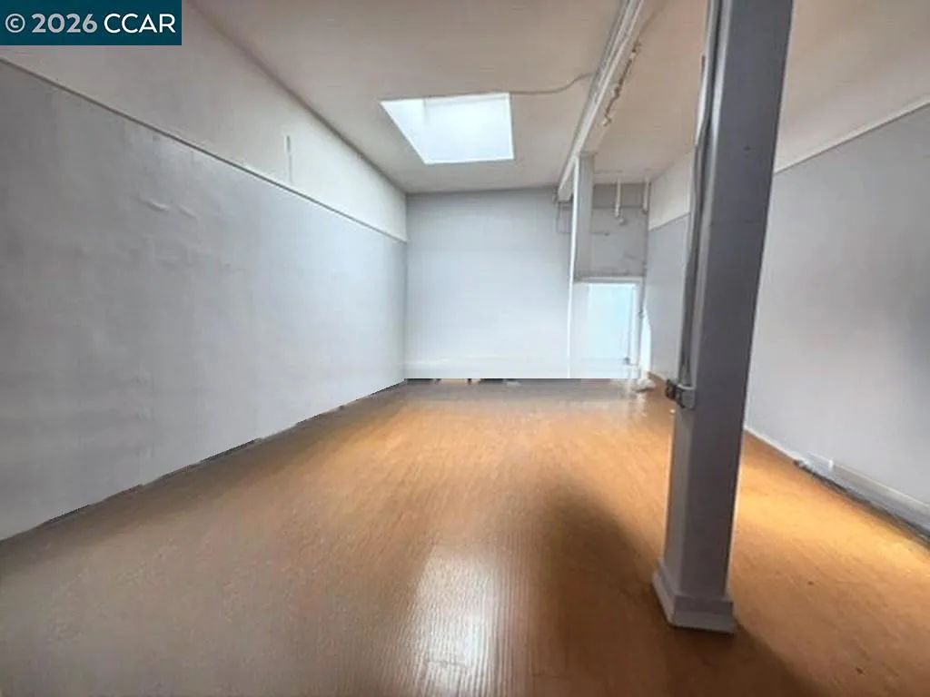 Main floor: open retail floor with skylight. Digitally altered: personal property and debris removed. Unaltered photo available.