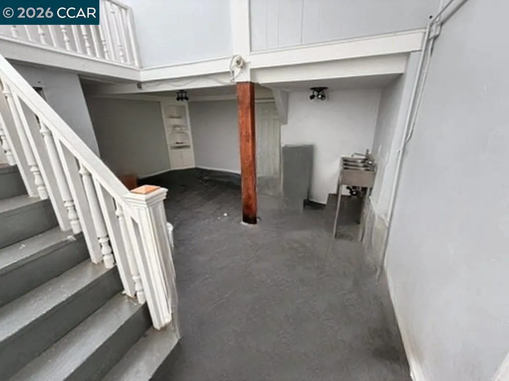 Stairs to lower level. Digitally altered: personal property and debris removed. Unaltered photo available.