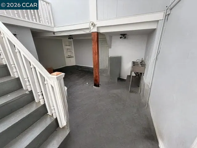 Stairs to lower level. Digitally altered: personal property and debris removed. Unaltered photo available.