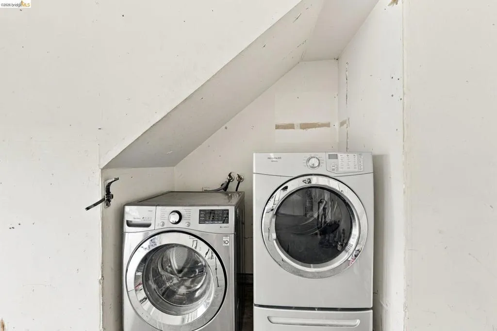 Dedicated laundry nook featuring angled structural wall framing and metal utility connections