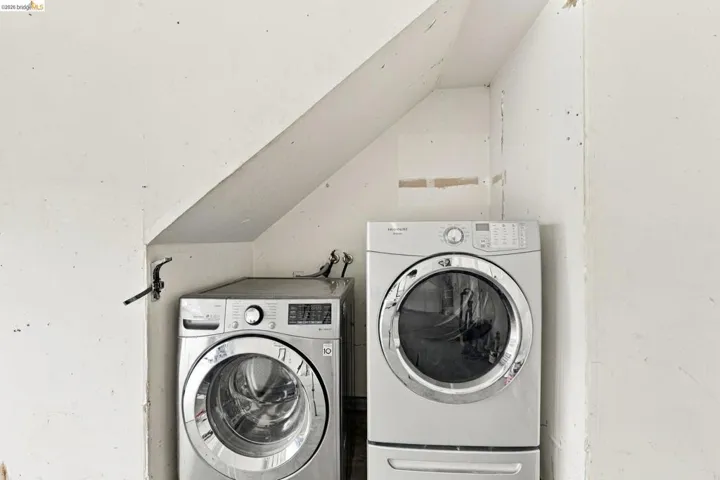 Dedicated laundry nook featuring angled structural wall framing and metal utility connections