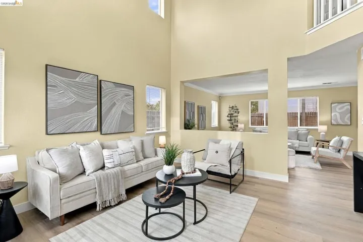 Double-height ceiling, wood-finish flooring, and large windows providing natural light