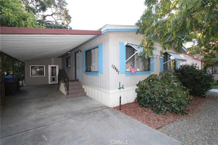Carport and recreation room with the entrance to the home. Retractable awnings.