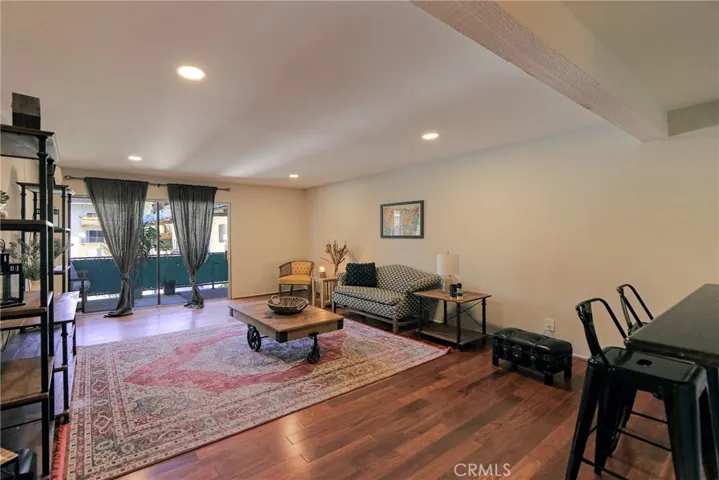 Charming Living Room with Smooth Ceilings, Recessed Lights and Stone Bar for Breakfast or Entertaining! Wood Floors and Balcony with a View of the Tennis Court!