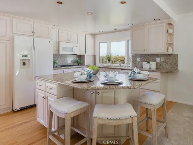 Open concept kitchen with island, granite countertops, custom cabinets.