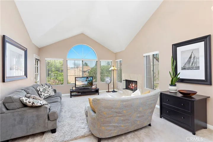 Large comfortable living area with lots of natural light, treetop views and a stunning stone fireplace.  Notice the sculpted architectural vaulted ceiling built to accentuate the Palladian style window.