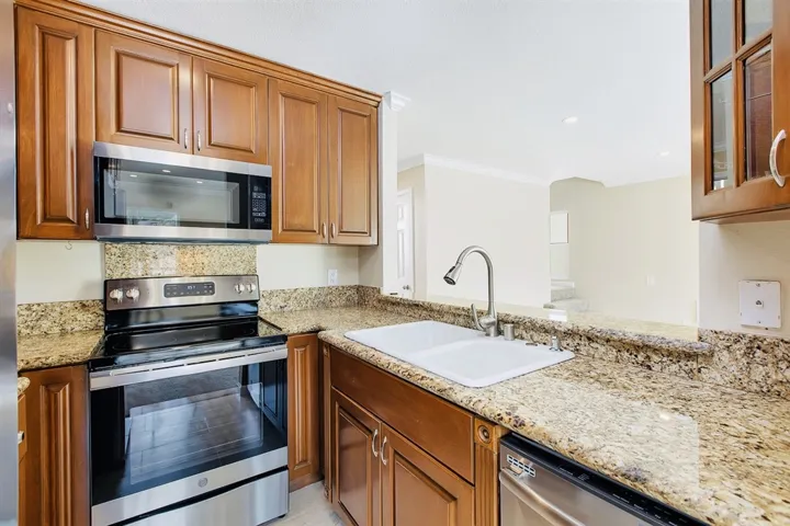 Double sink with designer faucet and glass front cabinets. Don't miss the Lazy Susans in cabinet corners.