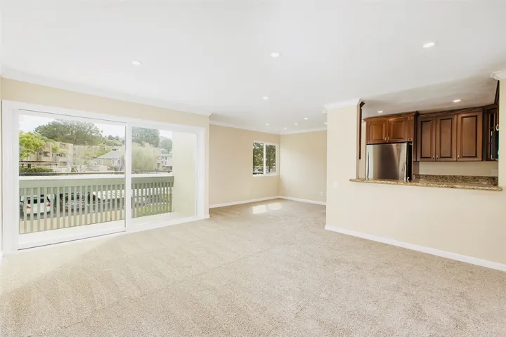 Living room with large patio/deck. Brand new carpet, paint, base and crown molding.