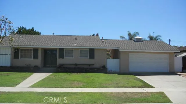 Front view of 1302 Kenneth with bright beds of color. 3 bedrooms 2 baths