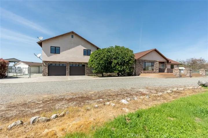 Front of house showing garage, another workshop/garage and pole barn roof