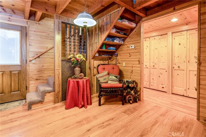 Main level living room area with staircase to the bedrooms and view of laundry closet and pantry in the walkway to the kitchen.