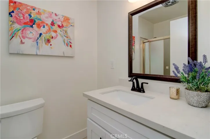 Gleaming hall bath has new fixtures, vanity and quartz countertop.