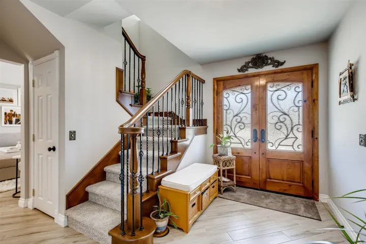 Foyer entry show cases the beautiful stair case to your right, family room barn door to your left, gorgeous kitchen straight ahead with tropical views of the stunning backyard!
