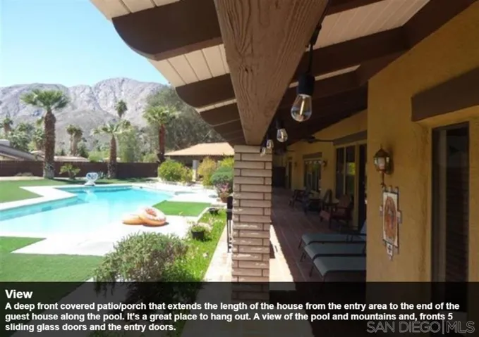 A deep front covered patio/porch that extends the length of the house from the entry area to the end of the guest house along the pool. It's a great place to hang out. A view of the pool and mountains and, fronts 5 sliding glass doors and the entry doors.