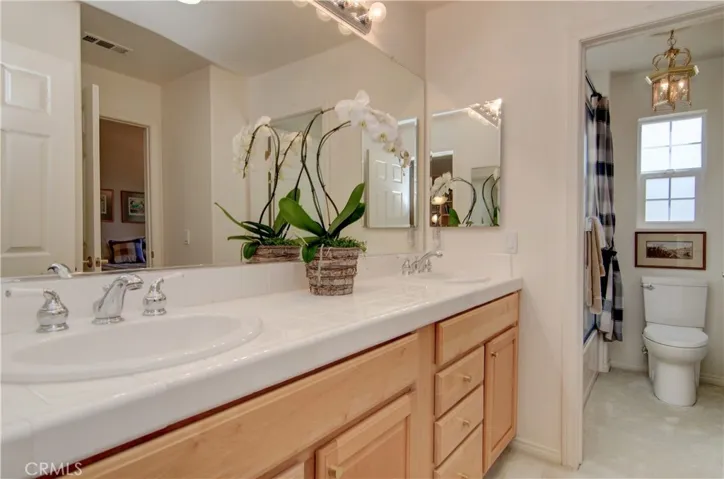 Jack and Jill bath has separate tub/toilet space and large vanity with double sinks.
