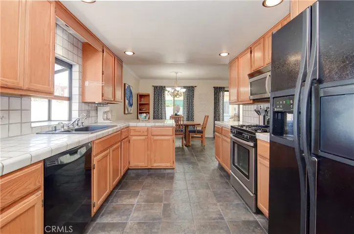 Beautiful slate flooring, rich wood cabinetry and recessed lighting add nice touches to this remodeled kitchen.