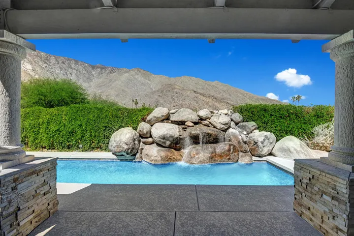 POOL WATERFALL TO MOUNTAINS FROM COVERED