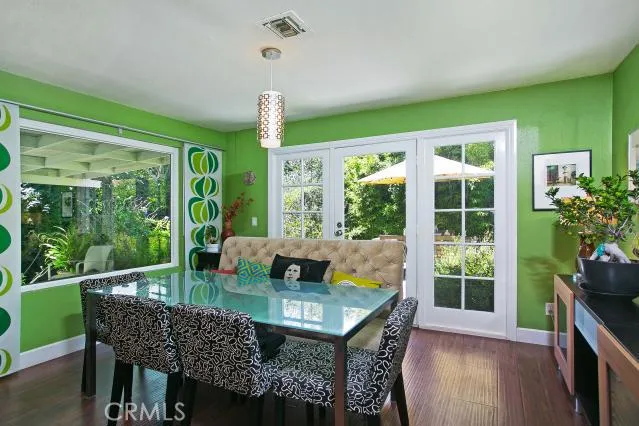 In nook, picture window and French doors that lead to backyard