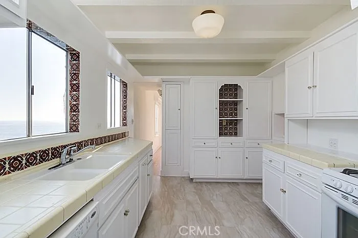 The kitchen has new flooring and beautiful appliances.