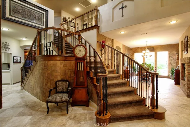 Beautiful double stairs picture #1.  Custom wrought iron staircase, with tumble lights. There is a large storage area under the stairs.  This house has a central vacuum on both levels.  Custom faux work on the first floor.