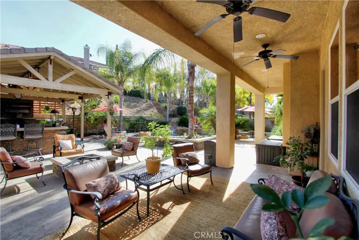 Sitting area just off the house looking towards the covered BBQ area, fire-pit and the pool