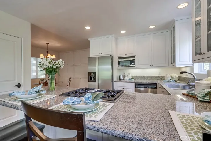 Looking into kitchen from the family room area over the eat up peninsula