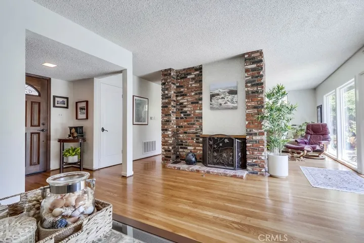 Living room showing den in the background that shares the double sided fireplace