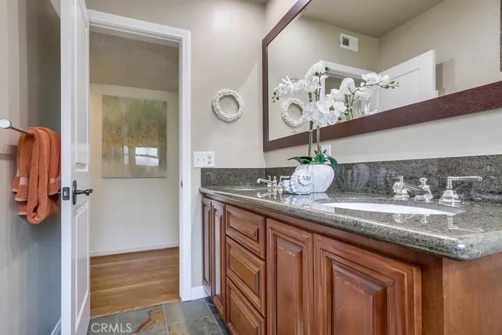 Remodeled hall bath featuring double sinks and a large walk in shower