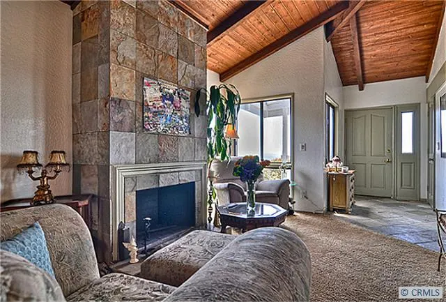 Note the cathedral ceilings with exposed beams in the living room.