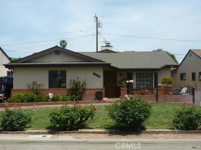 Front of home with rose garden, relax in your brick courtyard.