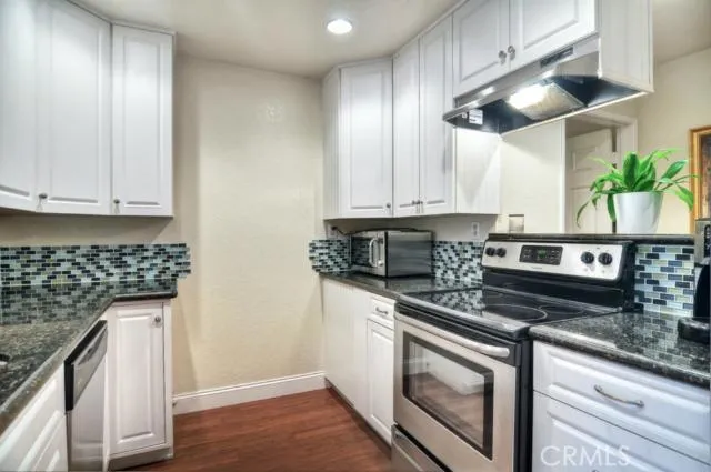 This kitchen has been expanded and opened up to the family room.  A large breakfast bar connects both rooms and a stainless steel range hood accents the eating space.