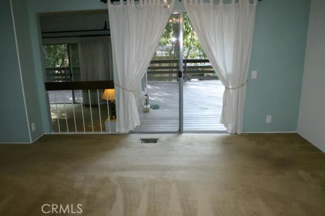 Closer view of dining room out to the wrap around deck and the surrounding trees