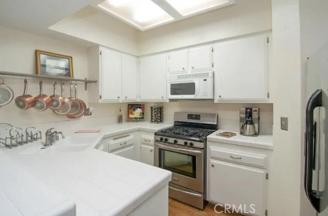 Very large, open, and bright kitchen features hardwood floors and cabinets that have been painted inside and out with new hardware.