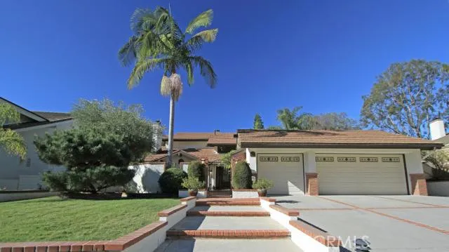 Front lawn, gated entrance and driveway with extra parking