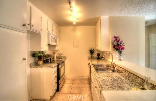 Beautiful granite counter tops with new stainless steel range, dishwasher, and sink.