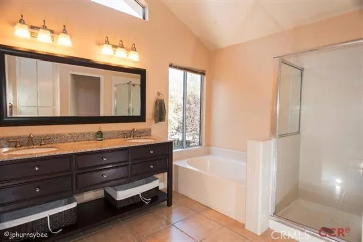 Master bathroom with beautiful vanity with double sinks. Separate tub and separate shower. Tiled flooring.
