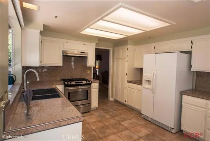 Remodeled kitchen with stainless steel appliances and granite tile countertops. Lots of cabinets and storage