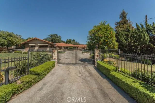 Front of house from street, beautiful rod iron gates with motor.
