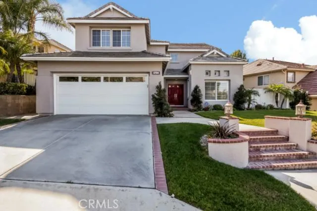 This beautiful brick and picture frame concrete walkway leads you to a large double door entry.