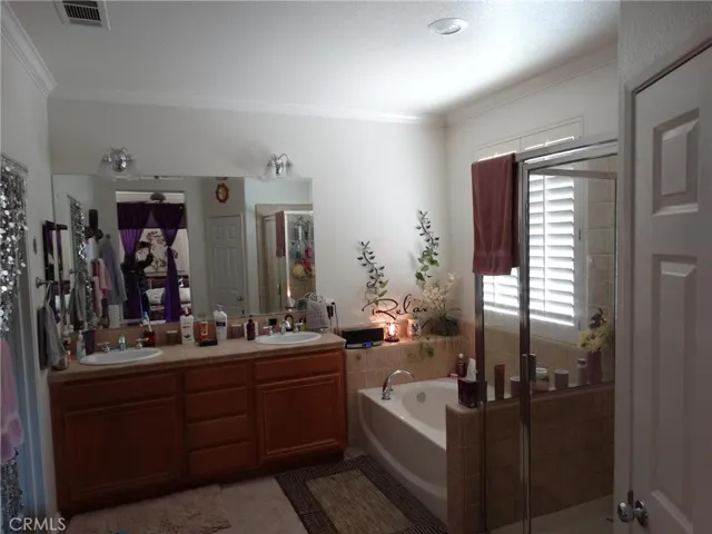 Master bathroom with double vanity, large soaker tub, separate shower and toilet area.