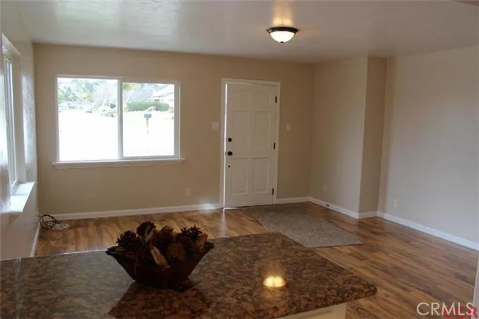 View of living from dining; new laminate wood floors, new interior paint, double paned windows.