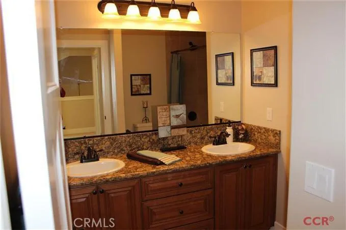 Guest bath on second floor, granite counter tops, tiled bath surround.