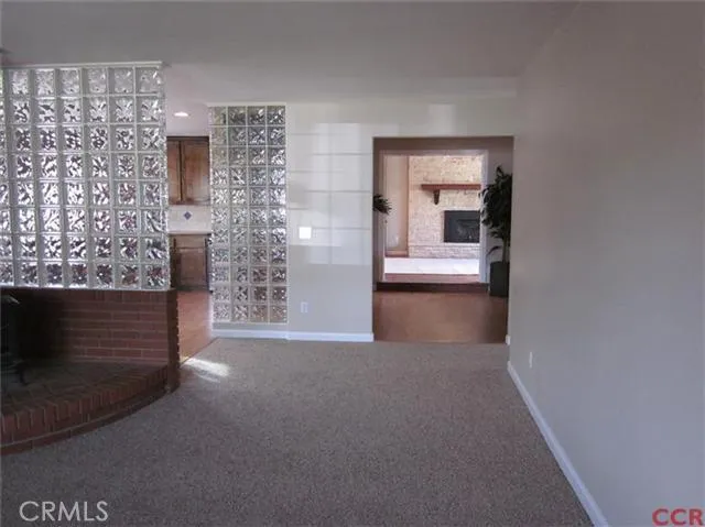 View from living room, peeking into kitchen, through dining room to family room. Exceptional glass block and brick work throughout home.