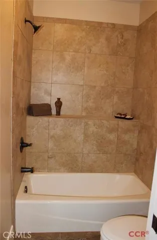 Hall bath with tile surround.