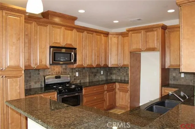 Full view of kitchen with breakfast bar; granite countertops and a classic style cabinetry