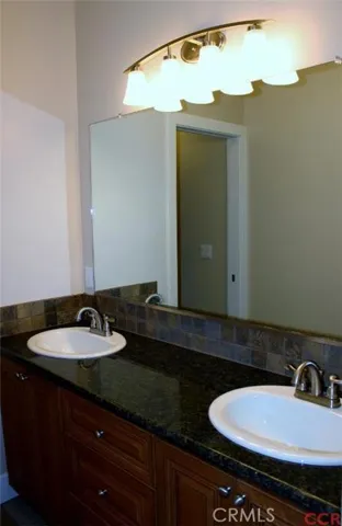 Hall bath with dual sink vanity, tile flooring and granite countertops