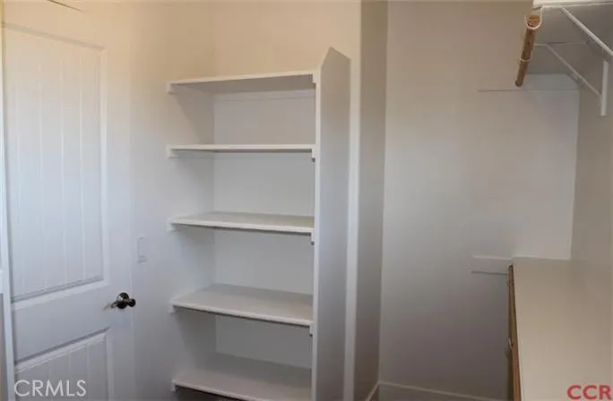 Large walk in closet with built in shelves and racks.