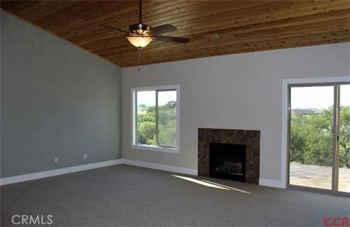 Living room features an accent wall with Venetian plaster finish, gas burning fireplace and exposed wood ceiling.