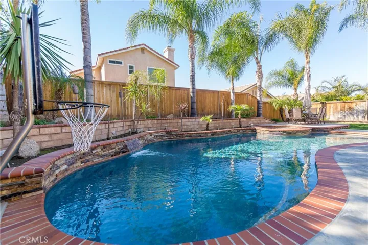 The expertly designed backyard features a sparkling pool and spa with a basketball and volleyball net - it also makes the perfect place to just hang by the pool and relax