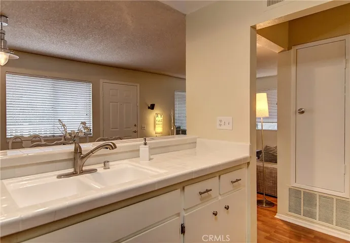 The kitchen gleams with coordinated cabinet hardware and bright white tile.